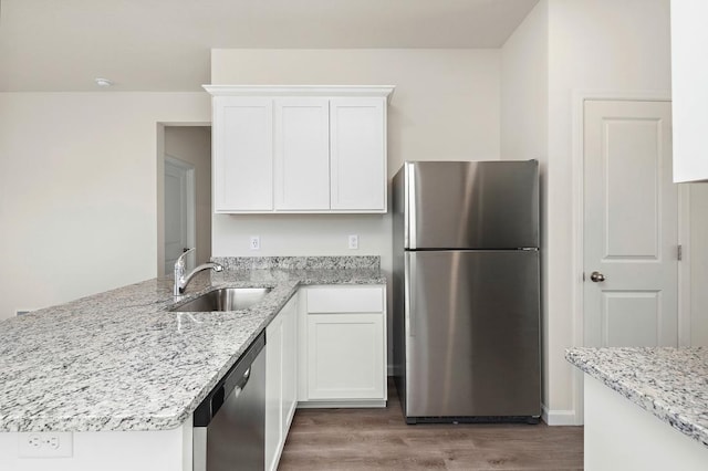 kitchen featuring appliances with stainless steel finishes, light stone countertops, sink, and white cabinets