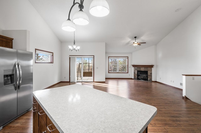 kitchen featuring dark hardwood / wood-style floors, stainless steel fridge, hanging light fixtures, and a kitchen island