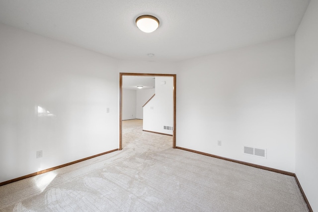 unfurnished room featuring light carpet