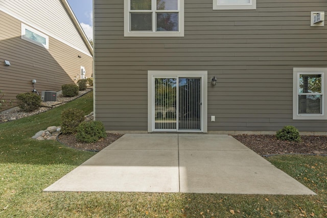 back of house featuring central AC, a yard, and a patio