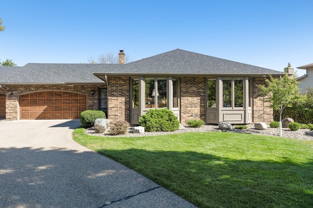 view of front of house with a garage and a front lawn