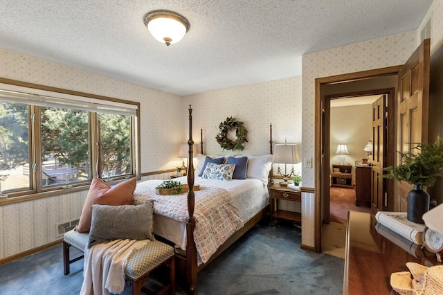 bedroom with dark carpet and a textured ceiling