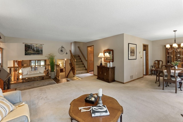 living room with an inviting chandelier, carpet floors, and a textured ceiling