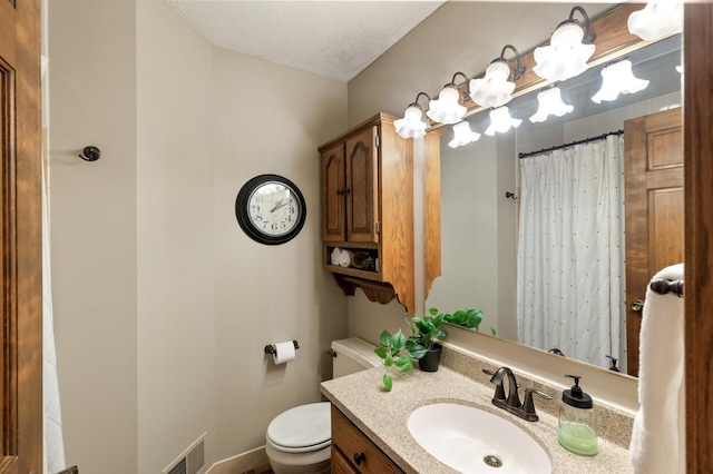 bathroom with vanity, curtained shower, a textured ceiling, and toilet