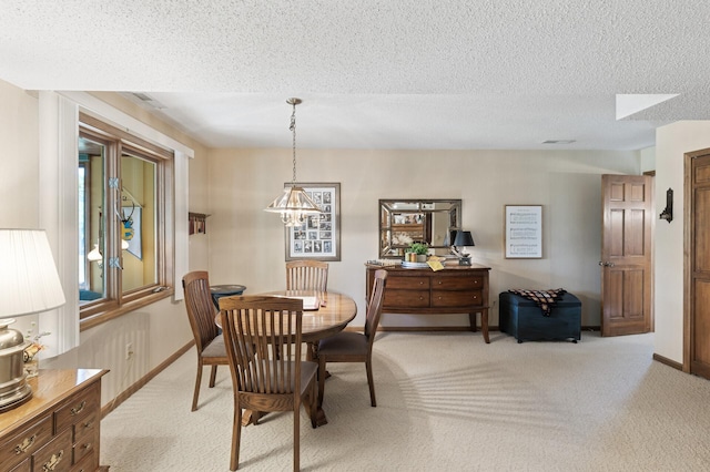 carpeted dining space featuring a textured ceiling