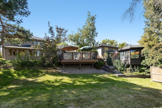 back of house featuring a sunroom, a yard, and a deck