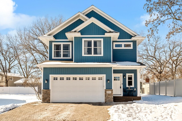 craftsman house featuring covered porch, a garage, fence, decorative driveway, and board and batten siding