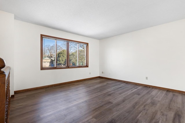 unfurnished room with dark wood-type flooring and a textured ceiling