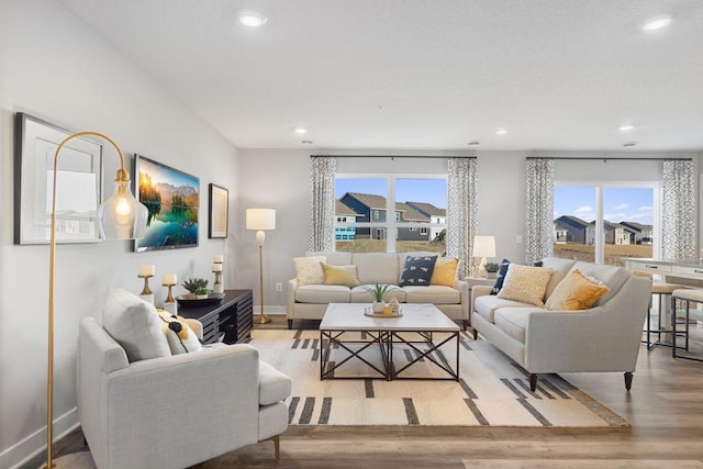 living room featuring light wood-style flooring, baseboards, and recessed lighting