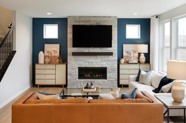 living room with a stone fireplace and light hardwood / wood-style flooring