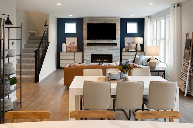 living room with a stone fireplace and light hardwood / wood-style floors