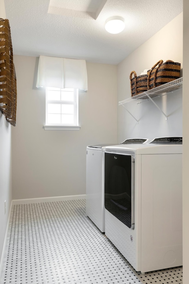 laundry room featuring a textured ceiling and washing machine and clothes dryer