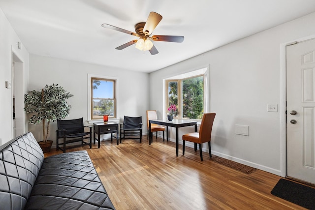 living area with hardwood / wood-style floors and ceiling fan