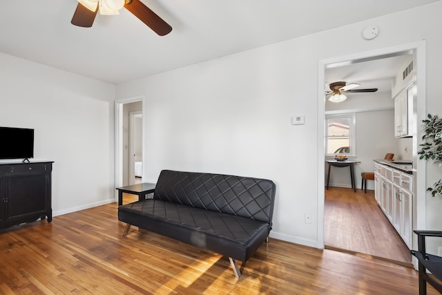 living area featuring hardwood / wood-style floors and ceiling fan