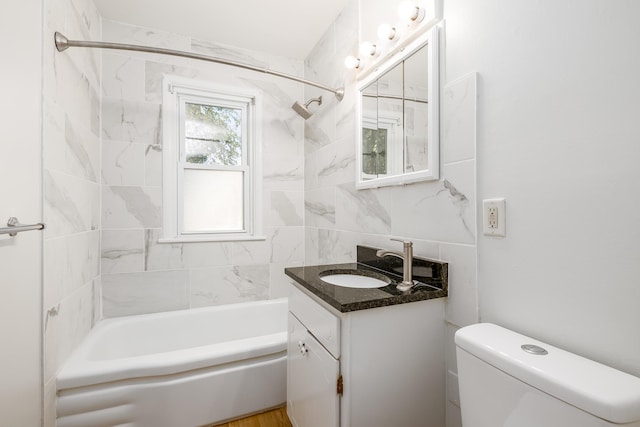 full bathroom featuring tiled shower / bath combo, vanity, and toilet