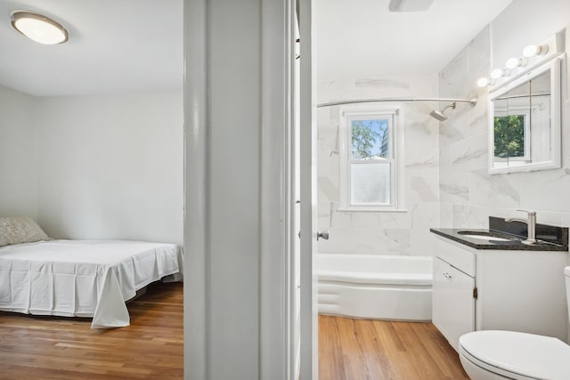 full bathroom with hardwood / wood-style floors, vanity, a wealth of natural light, and toilet