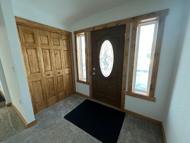 foyer entrance with carpet and lofted ceiling