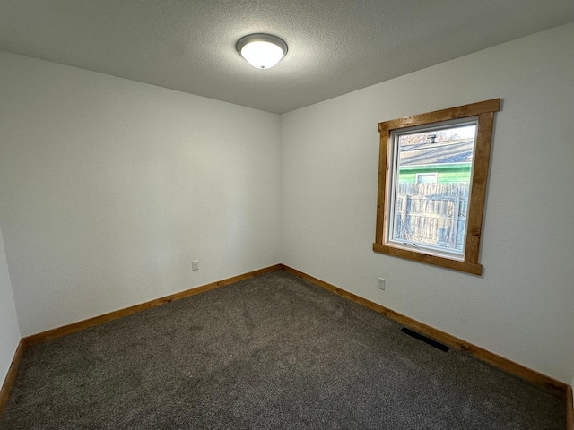 carpeted spare room featuring a textured ceiling