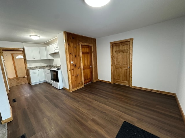 kitchen featuring dark hardwood / wood-style flooring, white cabinets, and electric range