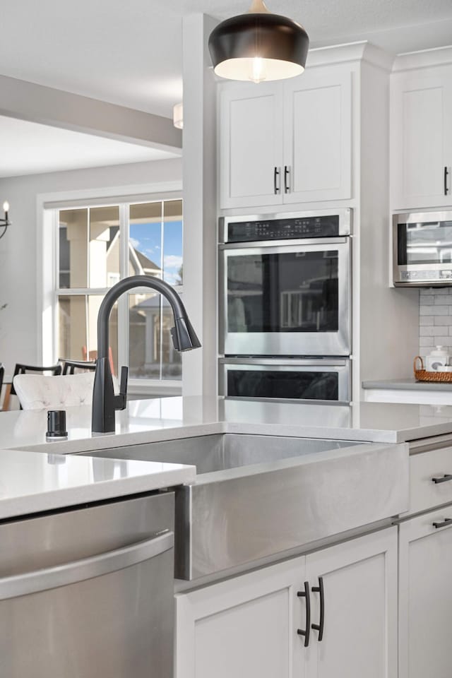 kitchen with white cabinetry, sink, decorative backsplash, and appliances with stainless steel finishes