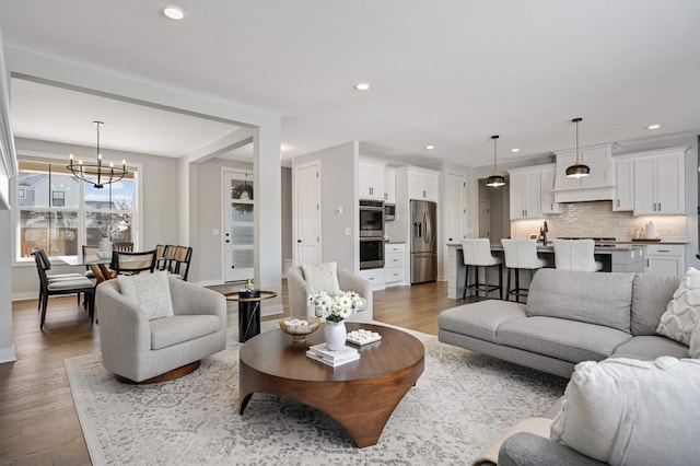 living room featuring dark wood-type flooring and an inviting chandelier