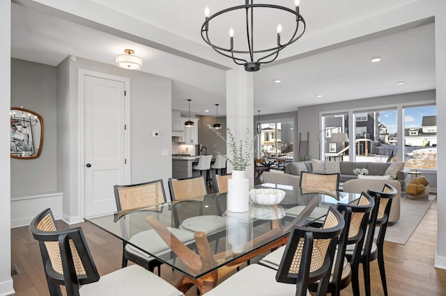 dining space featuring wood-type flooring and a chandelier