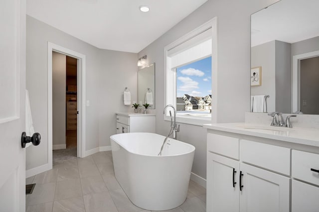 bathroom with tile patterned floors, vanity, and a washtub