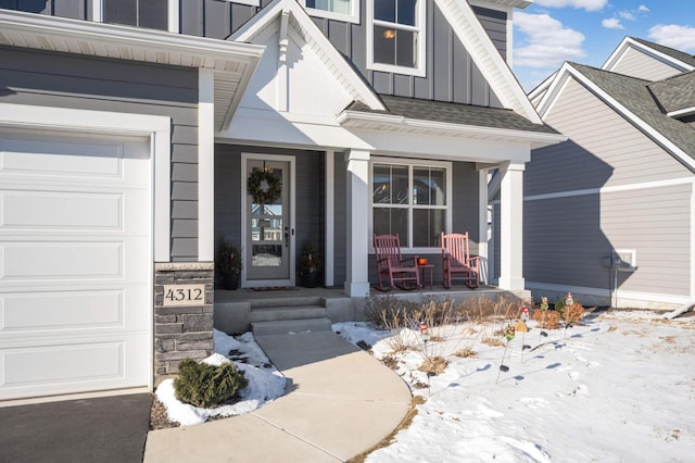 snow covered property entrance with covered porch