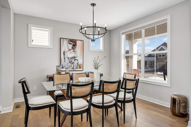 dining area featuring a notable chandelier and light hardwood / wood-style flooring