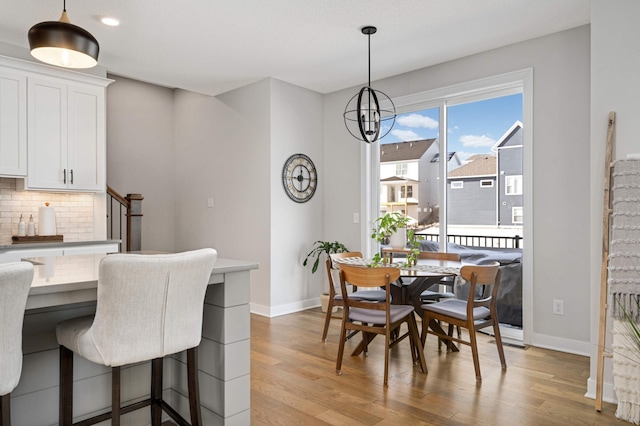 dining space featuring a notable chandelier and light wood-type flooring