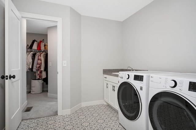 washroom featuring sink, washing machine and dryer, and cabinets