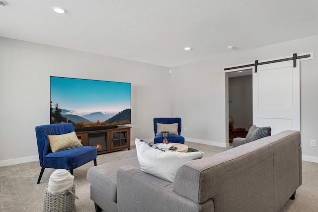 carpeted living room with a barn door and a textured ceiling