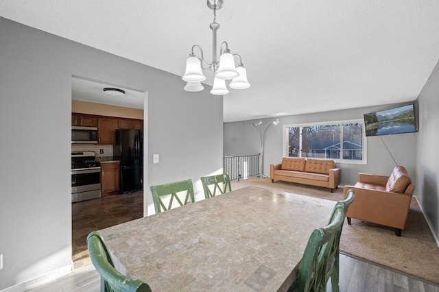 dining space featuring dark hardwood / wood-style flooring and an inviting chandelier