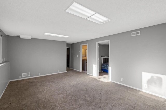 carpeted empty room with a textured ceiling