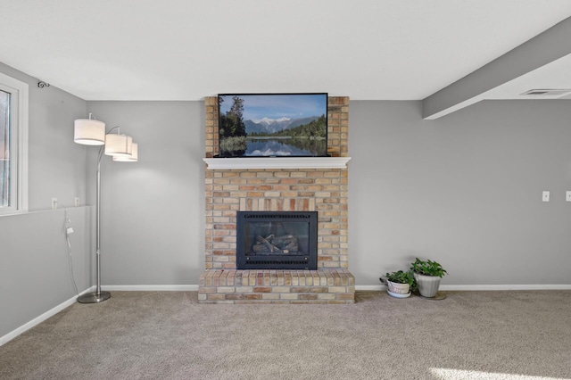 unfurnished living room with a fireplace, beamed ceiling, and carpet flooring