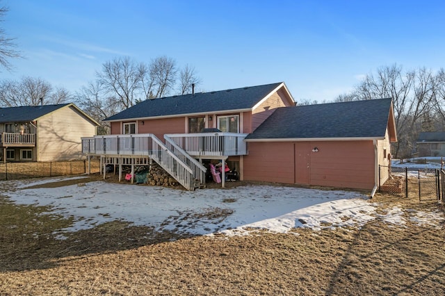 snow covered property featuring a wooden deck and a trampoline