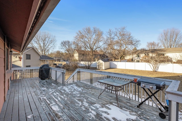 wooden deck with a storage shed and grilling area