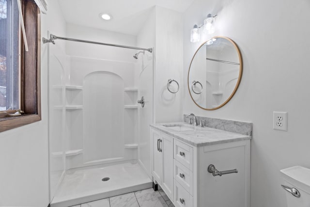 bathroom featuring vanity, toilet, and a shower