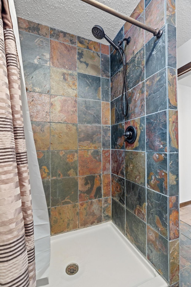 bathroom with a textured ceiling and a shower with shower curtain