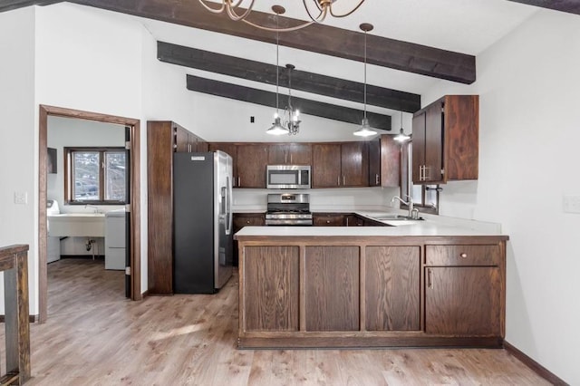 kitchen featuring appliances with stainless steel finishes, decorative light fixtures, lofted ceiling with beams, sink, and kitchen peninsula