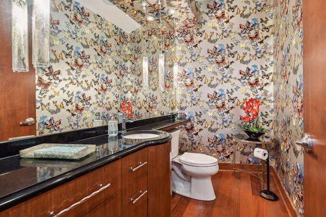 201 11th St Unit 2600, Minneapolis, MN 55403 - bathroom featuring wallpapered walls, wood finished floors, toilet, and vanity