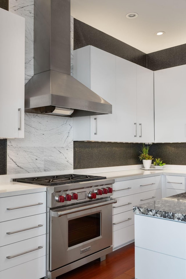 201 11th St Unit 2600, Minneapolis, MN 55403 - kitchen with premium range, wall chimney exhaust hood, white cabinets, backsplash, and recessed lighting