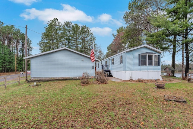 view of home's exterior featuring a lawn and fence