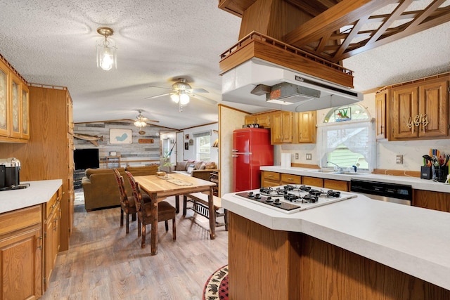 kitchen featuring a ceiling fan, a sink, white gas cooktop, lofted ceiling, and dishwashing machine