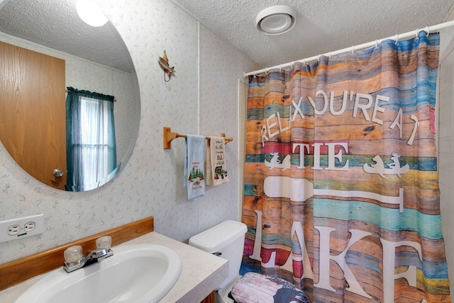 bathroom with vanity, a textured ceiling, a shower with shower curtain, and wallpapered walls