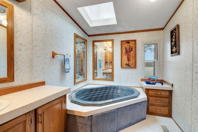 full bath with vanity, ornamental molding, a textured ceiling, and a garden tub