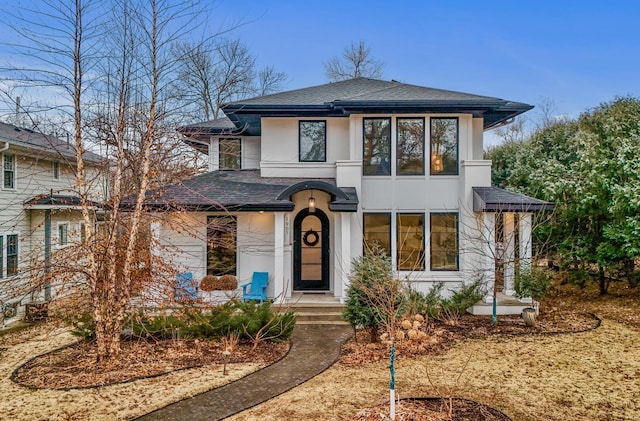 prairie-style house with a shingled roof and stucco siding