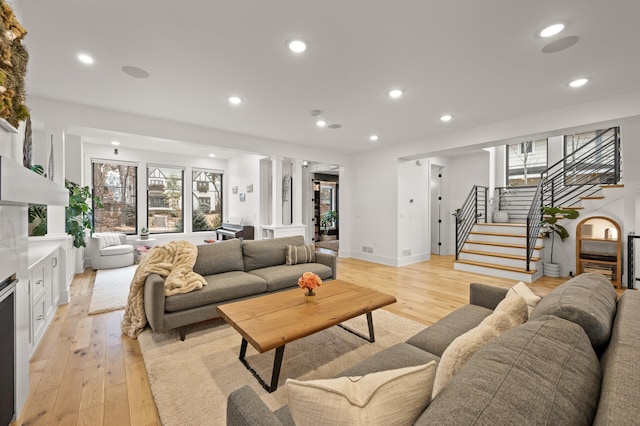 living area featuring light wood-type flooring, recessed lighting, stairway, and baseboards