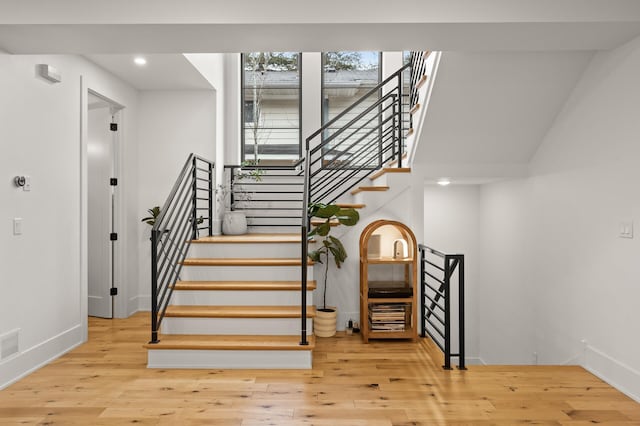 staircase featuring recessed lighting, wood-type flooring, and baseboards