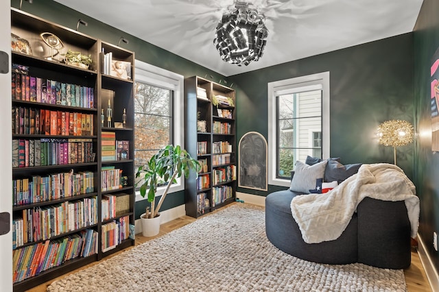 sitting room with baseboards, a wealth of natural light, and wood finished floors